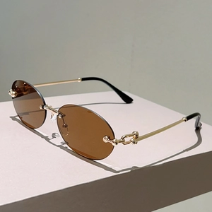 Détail des branches en métal doré avec maillons en U sur lunettes de soleil sans monture