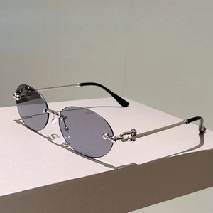 Détail des branches en métal argenté avec maillons de chaîne sur lunettes sans monture
