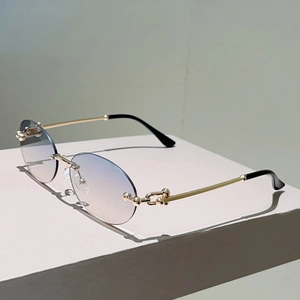 Détail de lunettes de soleil ovales sans monture avec branches dorées et joints sphériques