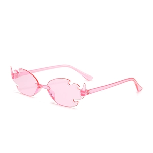 Detail of pink flame-shaped rimless sunglasses with unique flame silhouette lenses