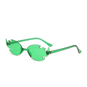 Detail view of emerald green flame-shaped rimless sunglasses for party and street style