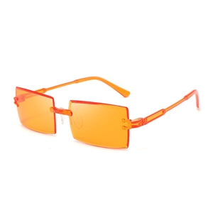 Detail of bright orange rimless rectangular sunglasses with transparent temples