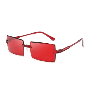Detail view of the red rimless rectangular sunglasses with metallic hinge joints