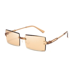 Close-up of rimless amber square sunglasses with elegant gold metal hinge detail