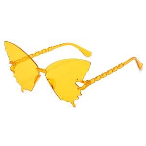 Détail de lunettes de soleil papillon jaunes avec des branches à texture de chaîne
