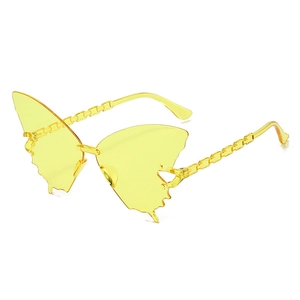 Détail de lunettes de soleil papillon jaunes avec des branches au design de chaîne