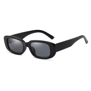 Detail view of vintage rectangle sunglasses featuring a thick glossy black frame and grey lenses