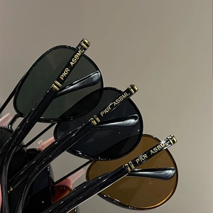 Detail of pilot sunglasses temples with gold metal hinges and brand logo engraving