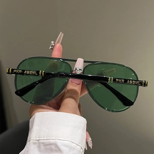 Detail of pilot sunglasses showing black frames and gold lettering on the temples
