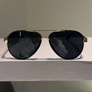 Classic aviator sunglasses with black frames and gold double bridge on a display stand