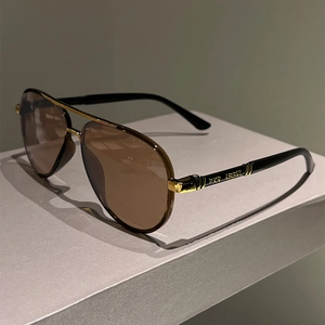 Detail view of pilot sunglasses featuring gold double bridge and PKR ASBNIL temple text