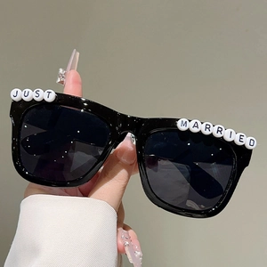 Close-up of black square sunglasses with white Just Married letter beads for bridal parties