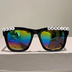 Close-up of Just Married square sunglasses with black frames and rainbow reflective lenses