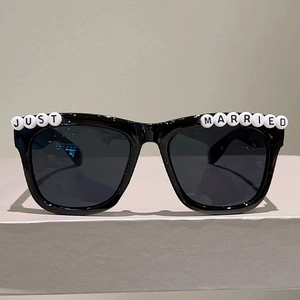 Detail of black party sunglasses featuring Just Married white letter bead embellishments