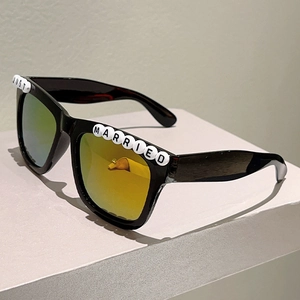 Close-up of Just Married letter beads on black square frame party sunglasses