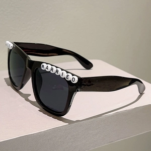 Detail of square black sunglasses with JUST MARRIED white letter beads for wedding party