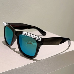 Detail of square black sunglasses with Just Married letter beads and blue mirrored lenses