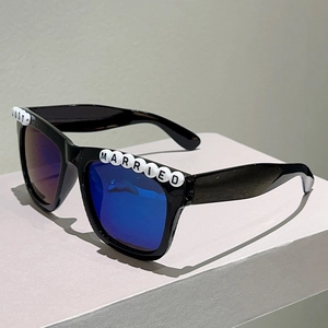 Detail of square black sunglasses with Just Married letter beads and blue mirrored lenses