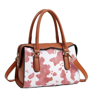 Retro cow print tote bag with brown leather handles and adjustable shoulder strap