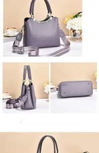 Detail view of purple leather handbag featuring wide jacquard strap and protective base studs