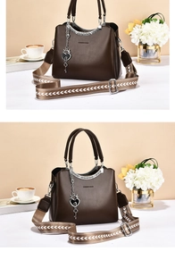 Detail of dark brown leather tote with fashion printing and heart pendant detail