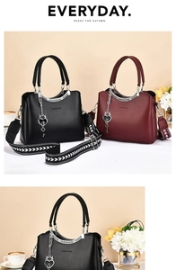 Close-up of stylish leather handbag with geometric woven strap and heart key charm detail