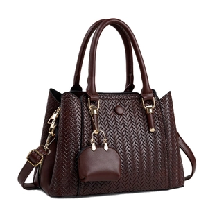 Dark brown woven texture handbag with shoulder strap and mini pouch charm on white background