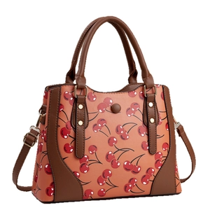 Pink Boston bag with cherry print and brown leather straps for women's crossbody wear