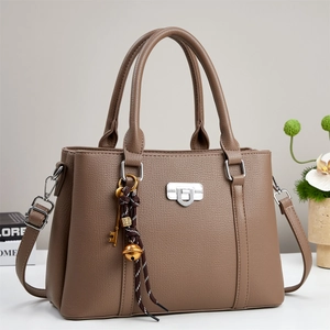 Brown lychee leather tote bag with silver lock and decorative pendant in minimalist style