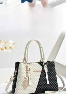 Detail of a chic handbag with black and white monogram print and gold hardware