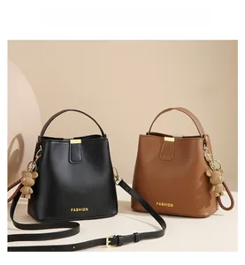 Detail of bucket bags in black and brown leather with cute bear charms and straps