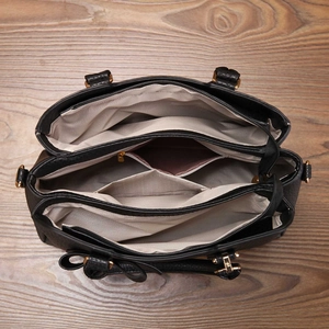 Macro view of multi-compartment interior with chevron lining on black bow tote bag