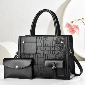 Detailansicht eines schwarzen Tragetaschen-Sets mit Krokodilmuster und kleiner Clutch
