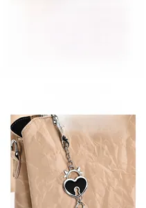 Close-up of pleated PU leather texture and heart-shaped metal charm on the handbag