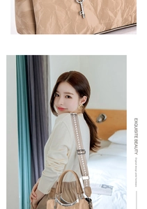Detail of pleated beige leather texture and wide woven shoulder strap with heart charm