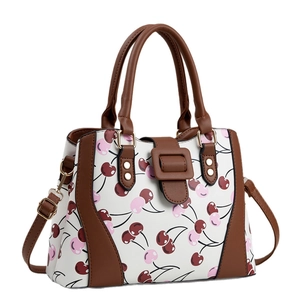 Sac à bandoulière blanc avec imprimé cerises et poignées marron vu de côté