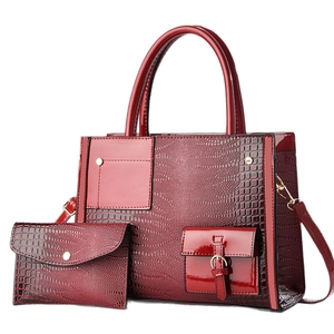 Deep red crocodile embossed leather handbag set with gold hardware and shoulder strap