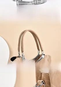 Detail view of khaki tote bag with wide soft leather handles and silver hardware