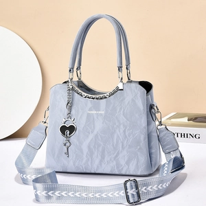 Light blue vintage tote bag with pleated texture, wide strap and heart pendant detail