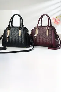 Detail of woven texture on vintage tote bags in black and wine red with gold flower pendant