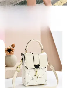 Detail of cream crossbody bag featuring a star charm and Mickey-shaped metal clasp