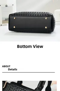 Detail of black woven handbag bottom with protective gold-toned metal feet studs