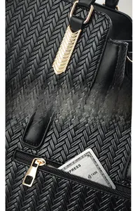Detailed macro shot of black woven leather texture and premium gold metal hardware zipper