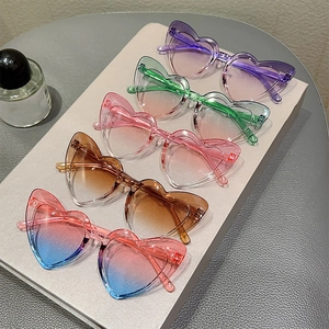 Detailed view of colorful heart-shaped rimless sunglasses for kids in various gradient shades