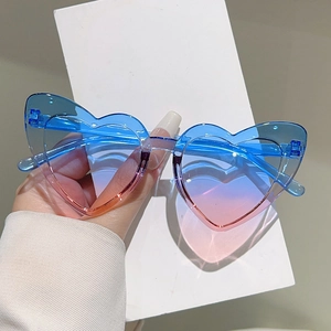 Detail of heart-shaped kids sunglasses with blue and pink gradient lenses for parties
