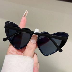 Detailed close-up showing heart-shaped baby sunglasses with black frames and dark lenses