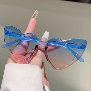 Detail of heart-shaped kids sunglasses with blue pink gradient lenses and blue frame