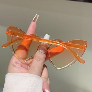 Detail shot of heart-shaped kids sunglasses in translucent amber orange finish