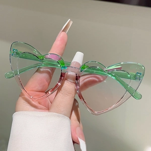 Detail of heart-shaped rimless sunglasses featuring a green to pink gradient lens design