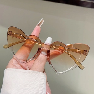 Detailed view of heart-shaped kids sunglasses with brown gradient lenses and translucent frame